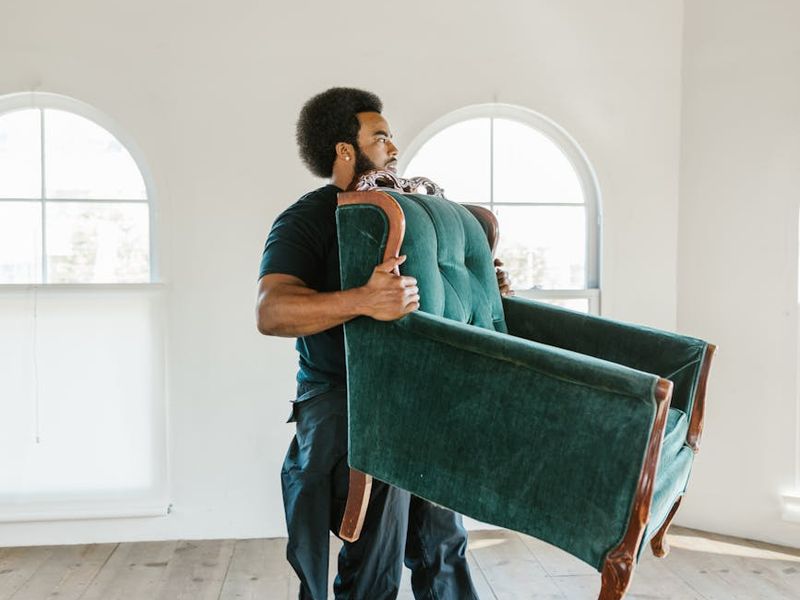 Person performing a deliberate yoga move in a bright, minimalist room.